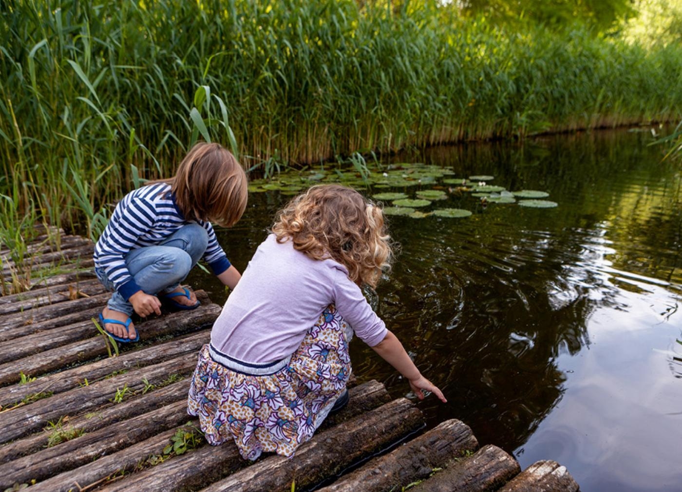 Twee kinderen spelen met water in het Arboretum-Heempark Delft Twee kinderen spelen met water in het Arboretum-Heempark Delft