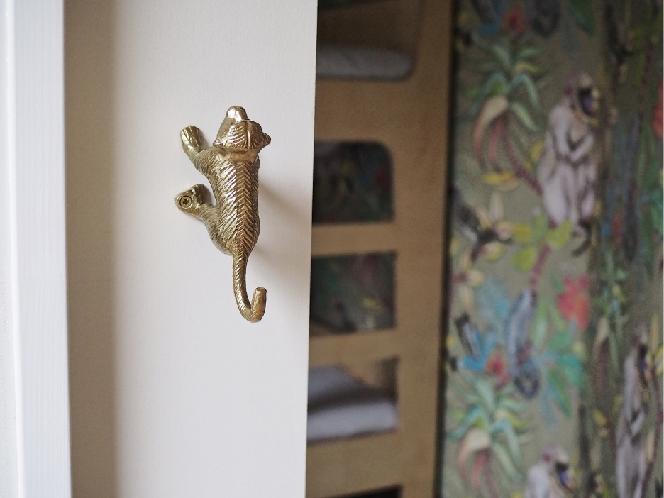 Detail van de kinderslaapkamer met stapelbed en cole and son apenbehang en een aap handgreep op een schuifdeur in vakantiehuisje de Tuinkers Detail van de kinderslaapkamer met stapelbed en cole and son apenbehang en een aap handgreep op een schuifdeur in vakantiehuisje de Tuinkers